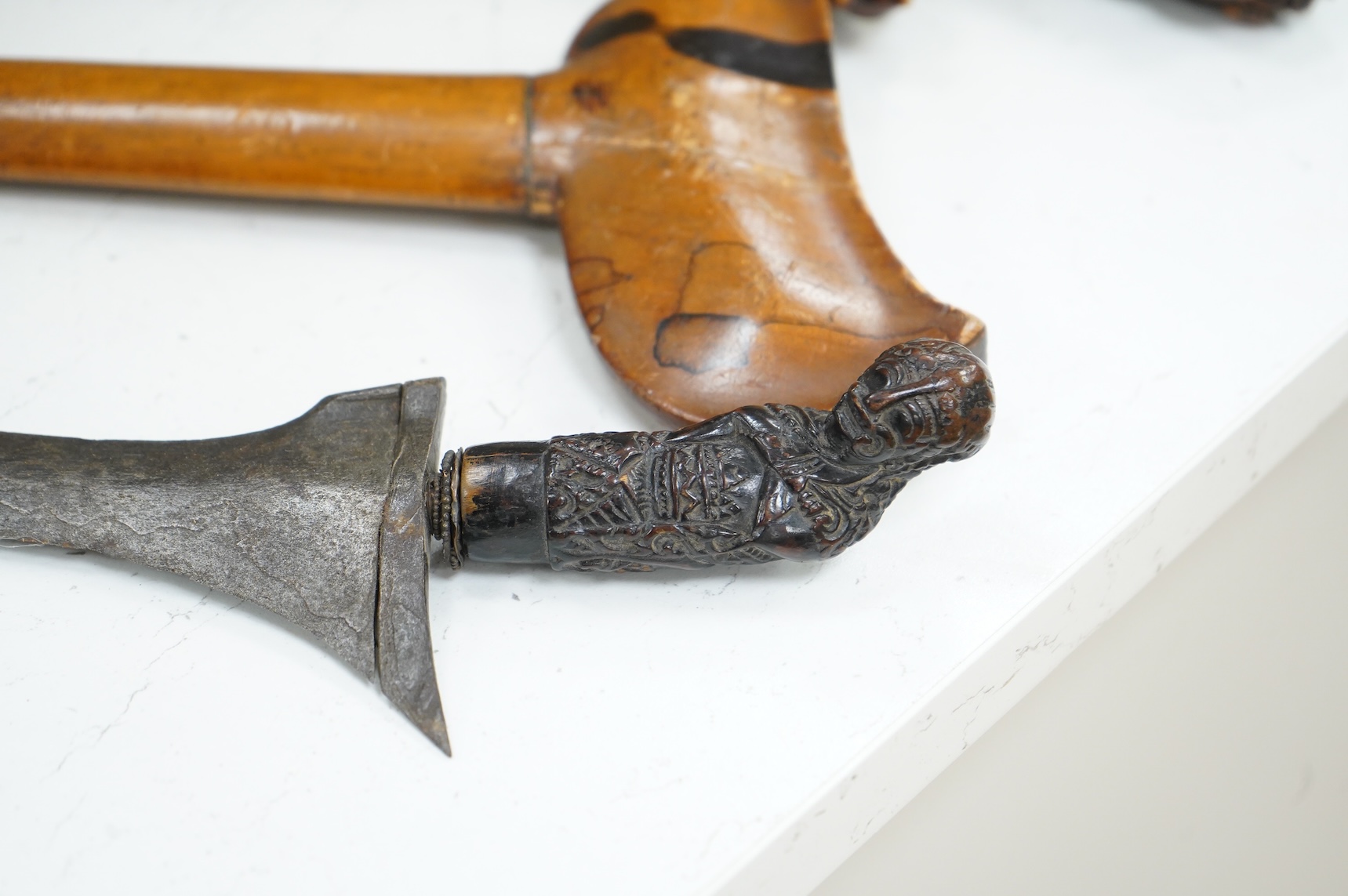 A Javanese dagger kris with straight pamor blade, wooden hilt carved as raksha, in its wooden sheath, together with a decorative dagger bade-bade, with etched blade